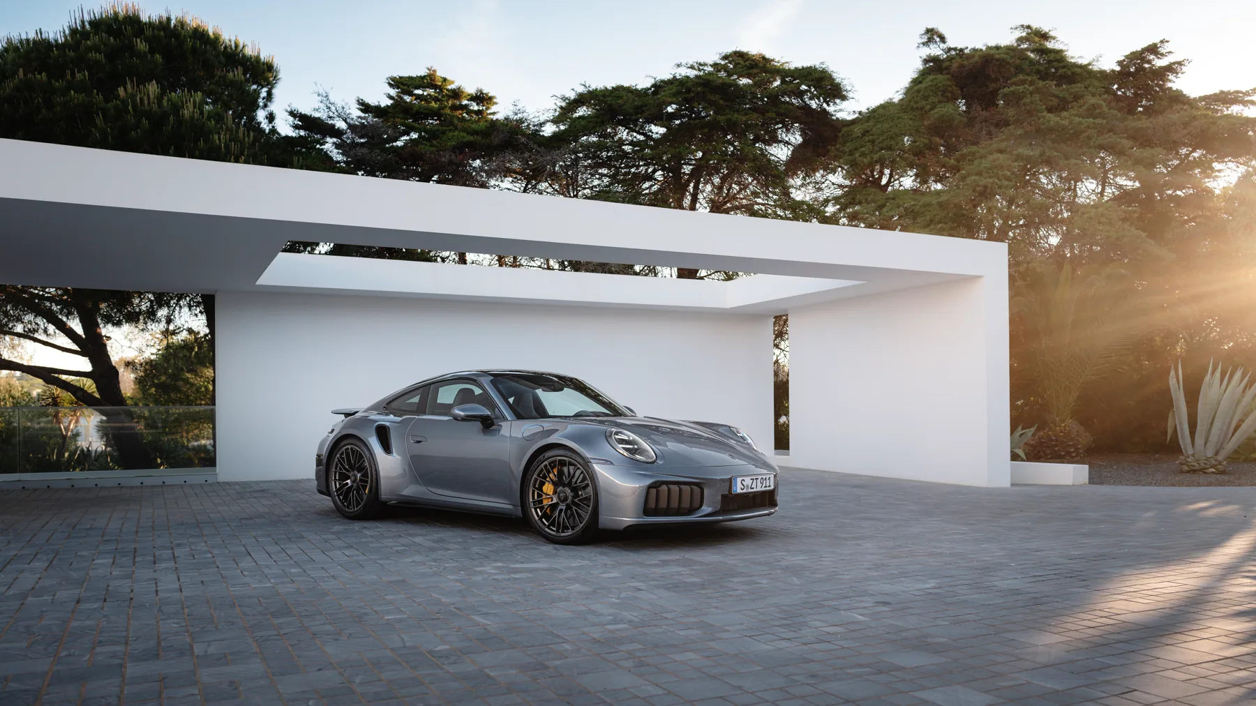 Gray 2026 Porsche 911 Turbo S, dead-front with tinted main headlamp units and corner cooling intakes