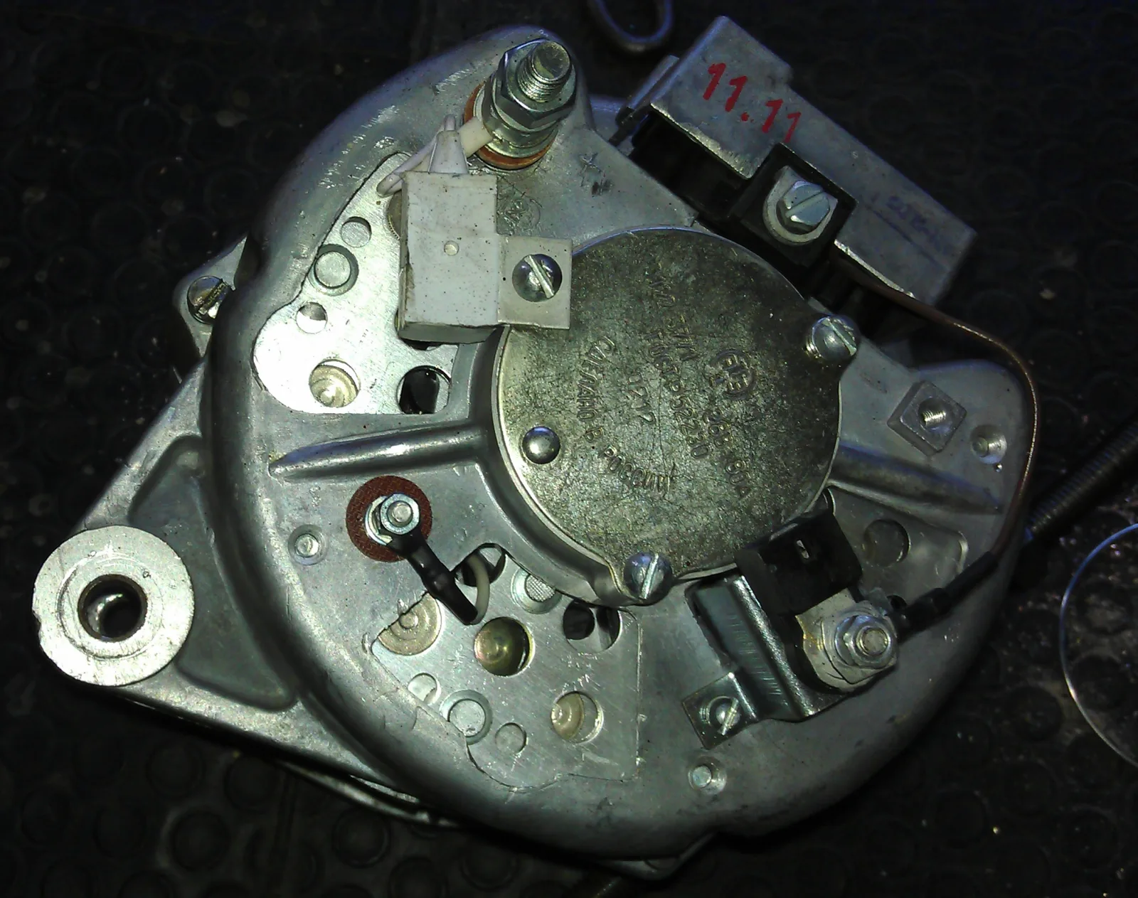 Rear of an automotive alternator with B-plus studs, wiring, and a 14-volt stamp