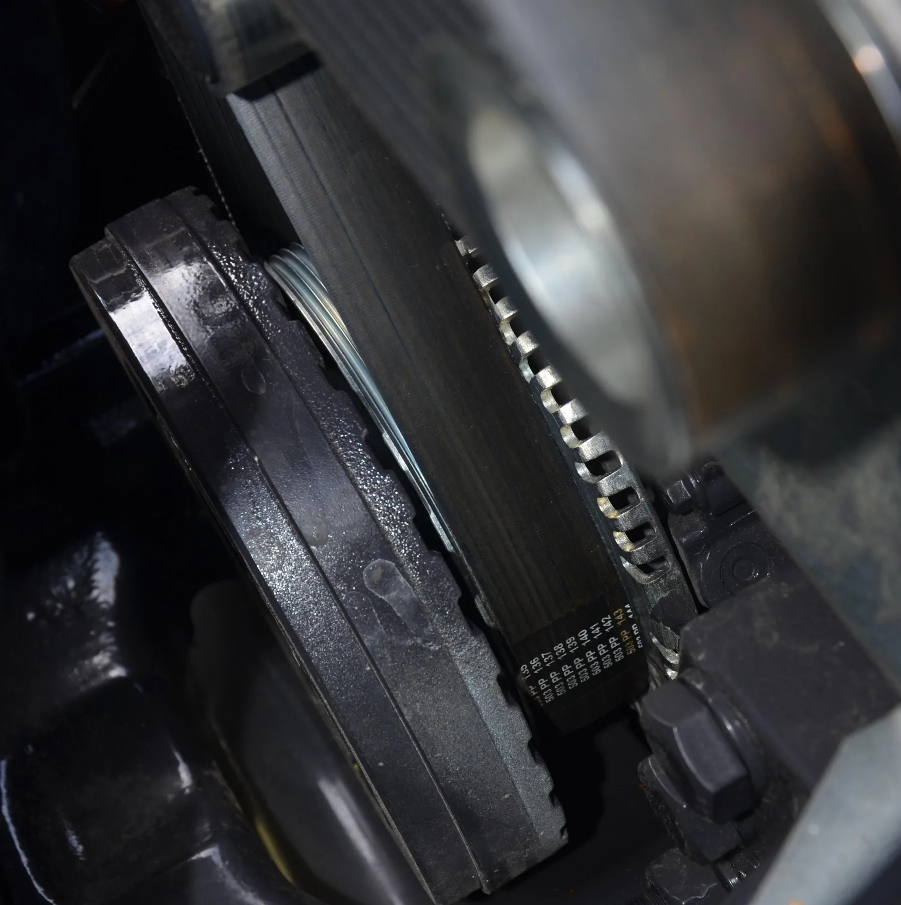 Ribbed face of a poly-v serpentine belt with printed size marks