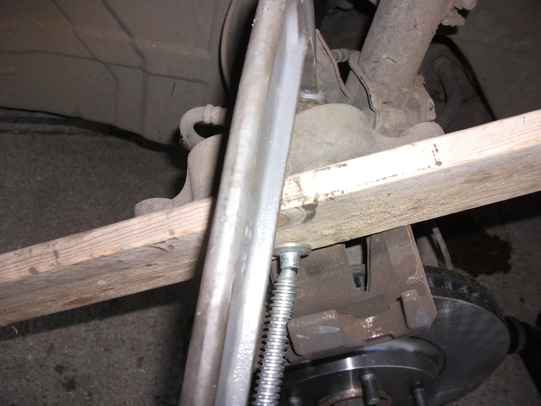 C-clamp and wood block retracting a caliper piston in a wheel well