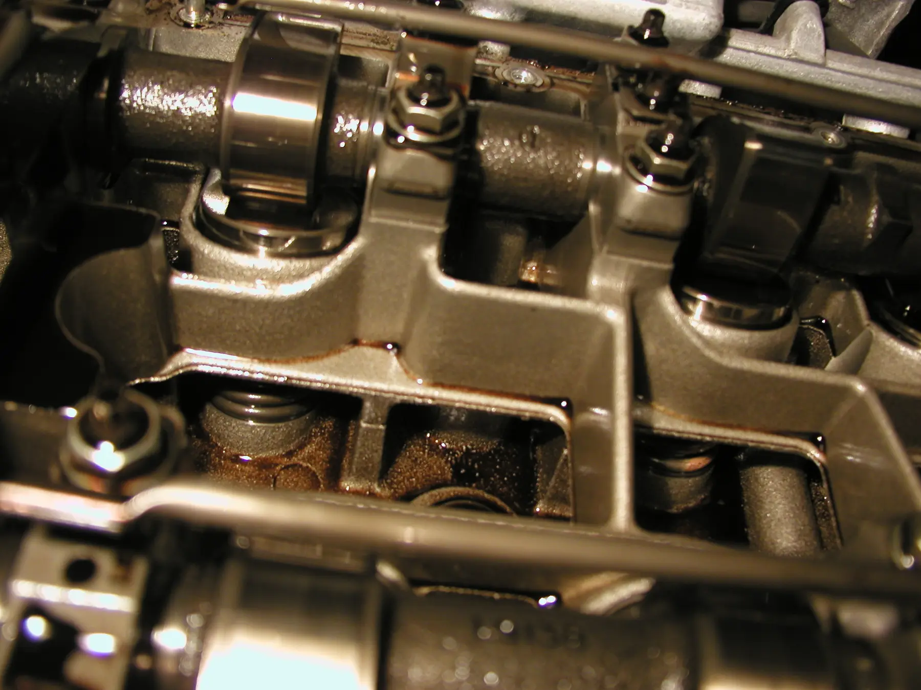 Close view of a cam lobe above a tappet in a cylinder head