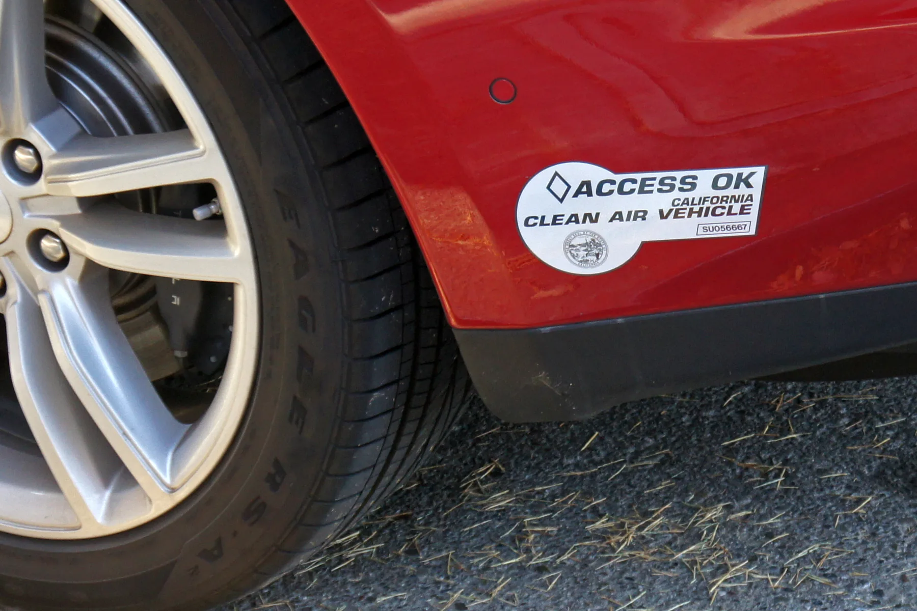 Clean Air Vehicle decal on the rear bumper of a white Tesla Model S, the California sticker that marked a car for carpool-lane access