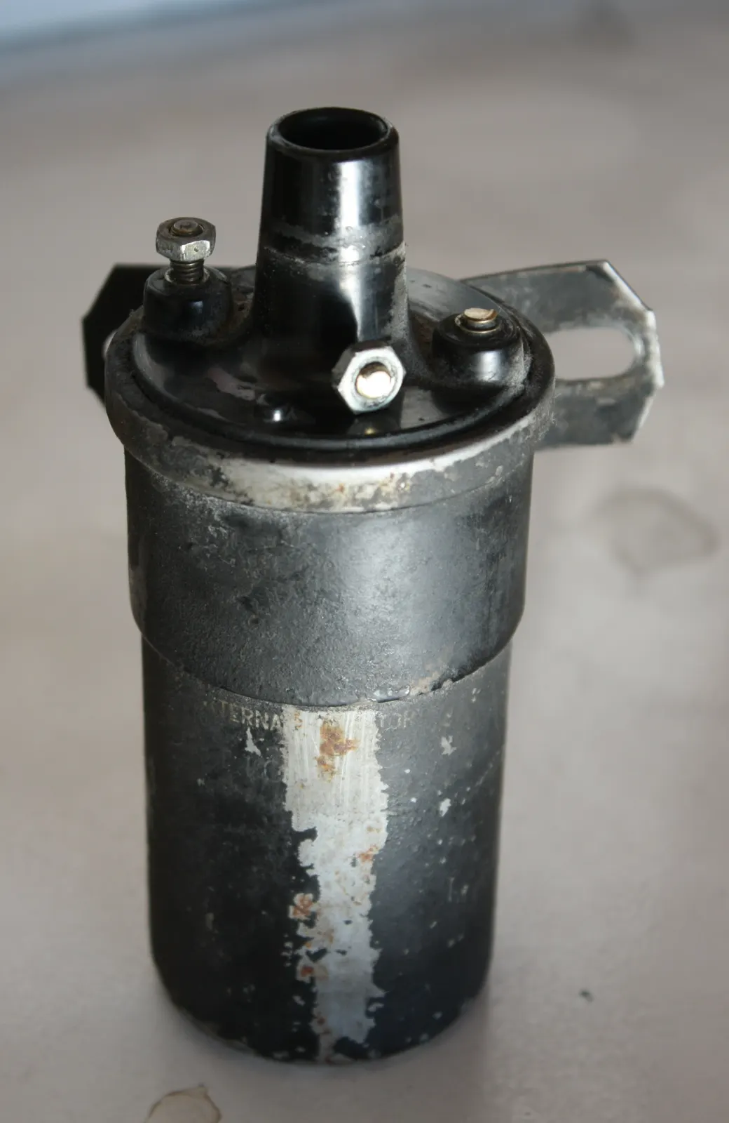 Black canister ignition coil with a high-voltage tower and two primary screw terminals