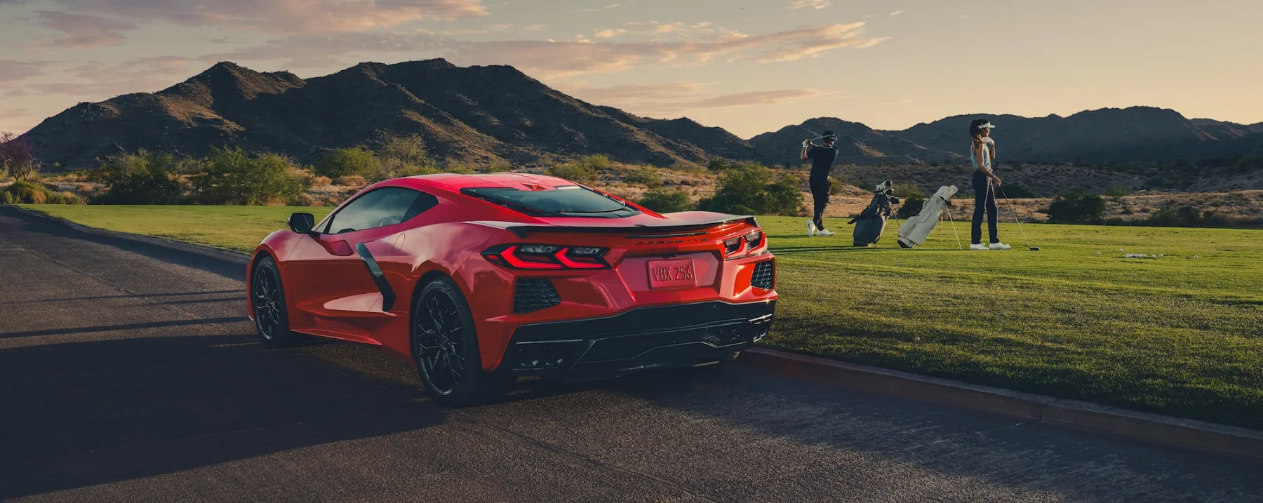 Red 2026 Chevrolet Corvette Stingray, rear three-quarter with a glass hatch, flying buttresses, and dual-element tail lamps