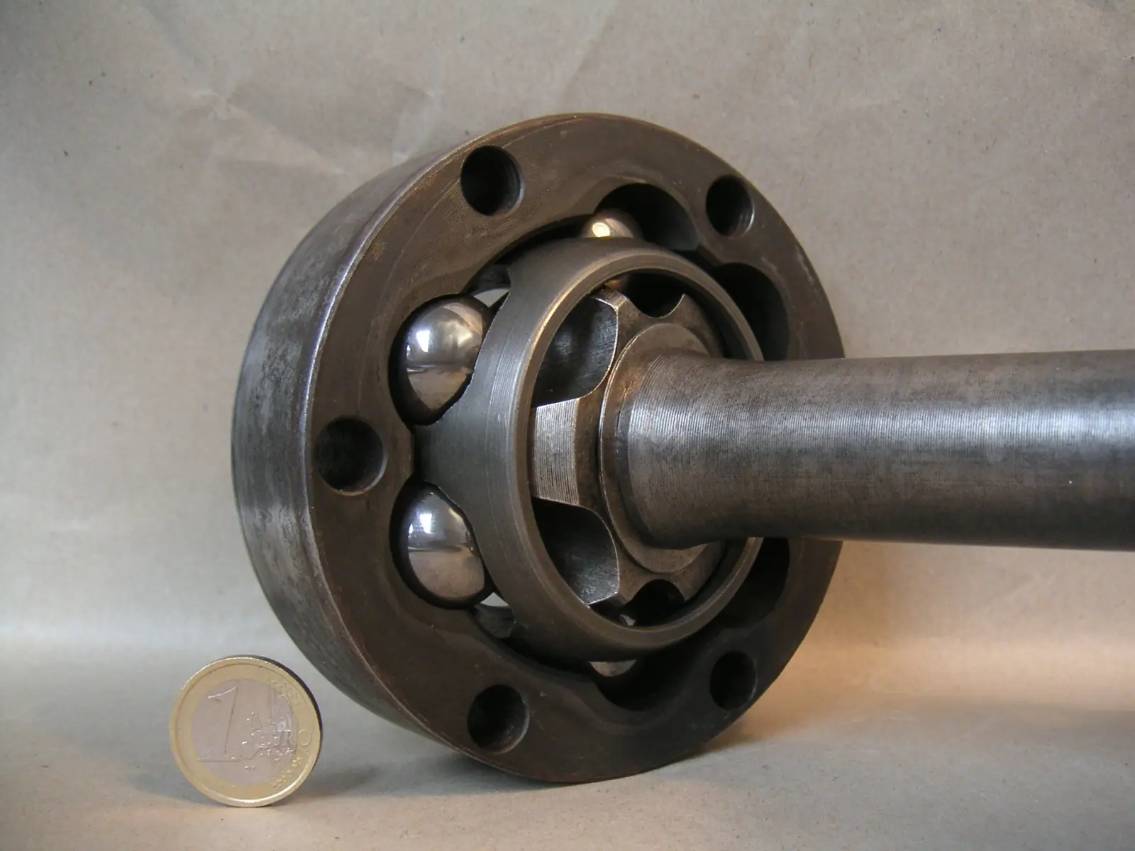 Open Rzeppa-style CV joint, six balls in a cage on a shaft, euro coin for scale