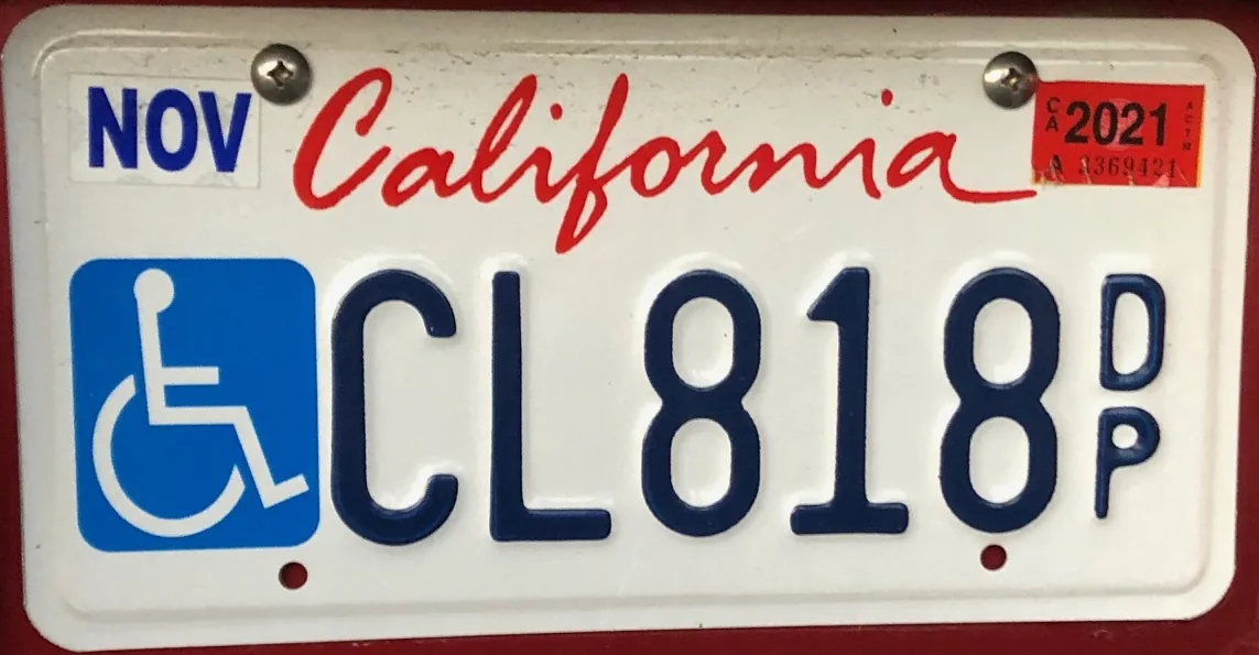 California disabled person plate with a wheelchair symbol at left and DP suffix at right