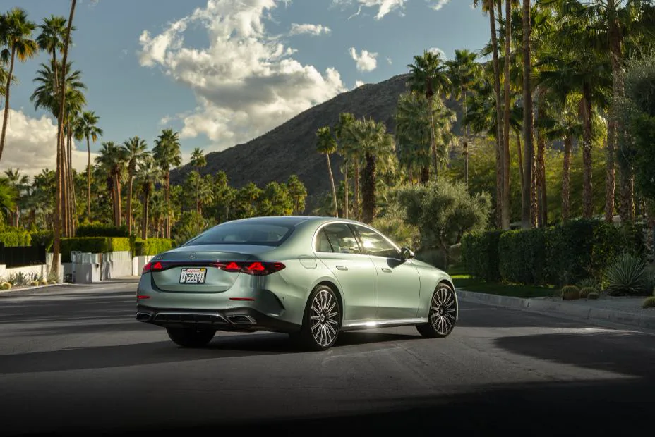Verde Silver 2026 Mercedes-Benz E-Class sedan, rear three-quarter on a palm-lined street