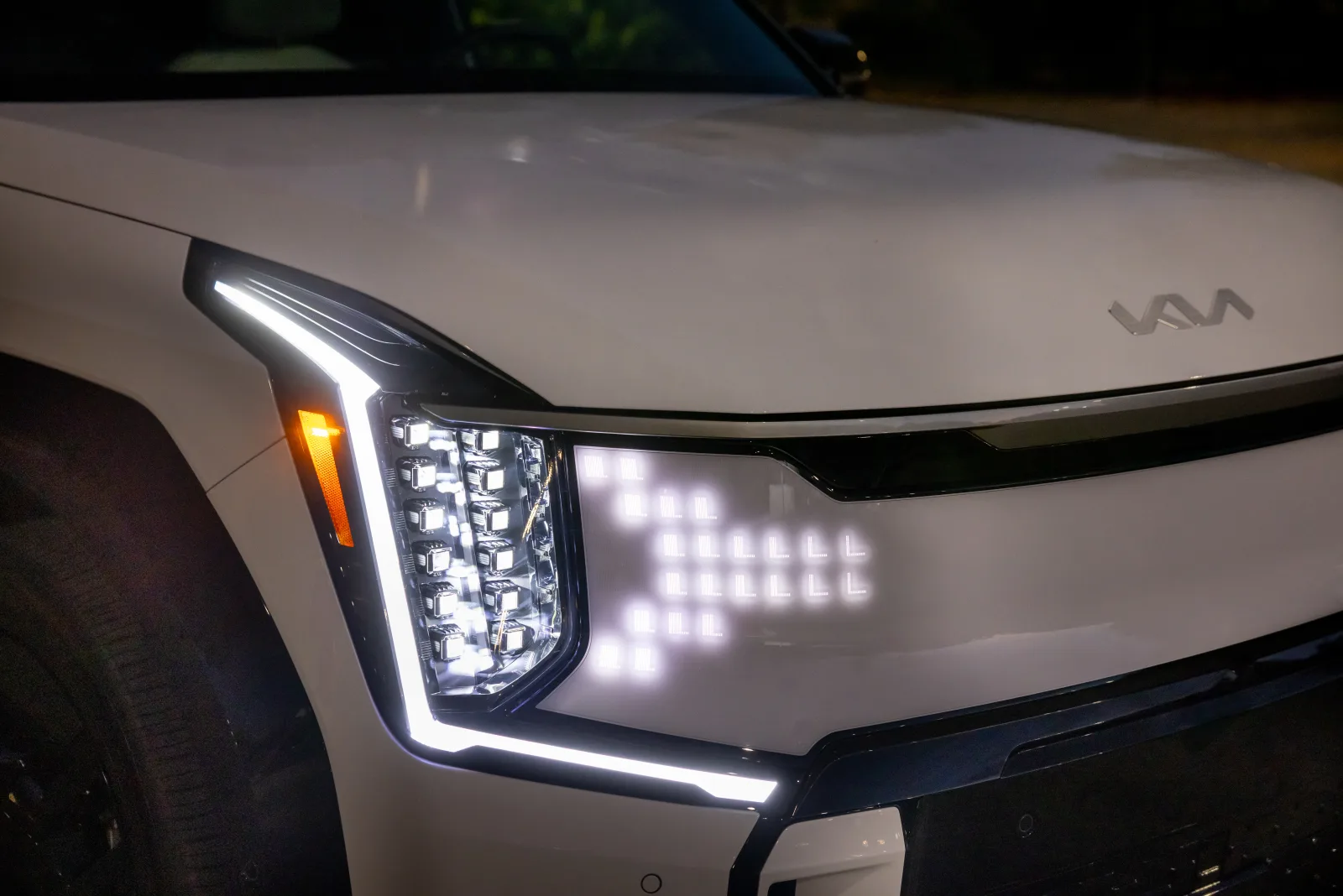 Close 2026 Kia EV9 front lamp stack and star-pixel tiger-nose on a white fascia