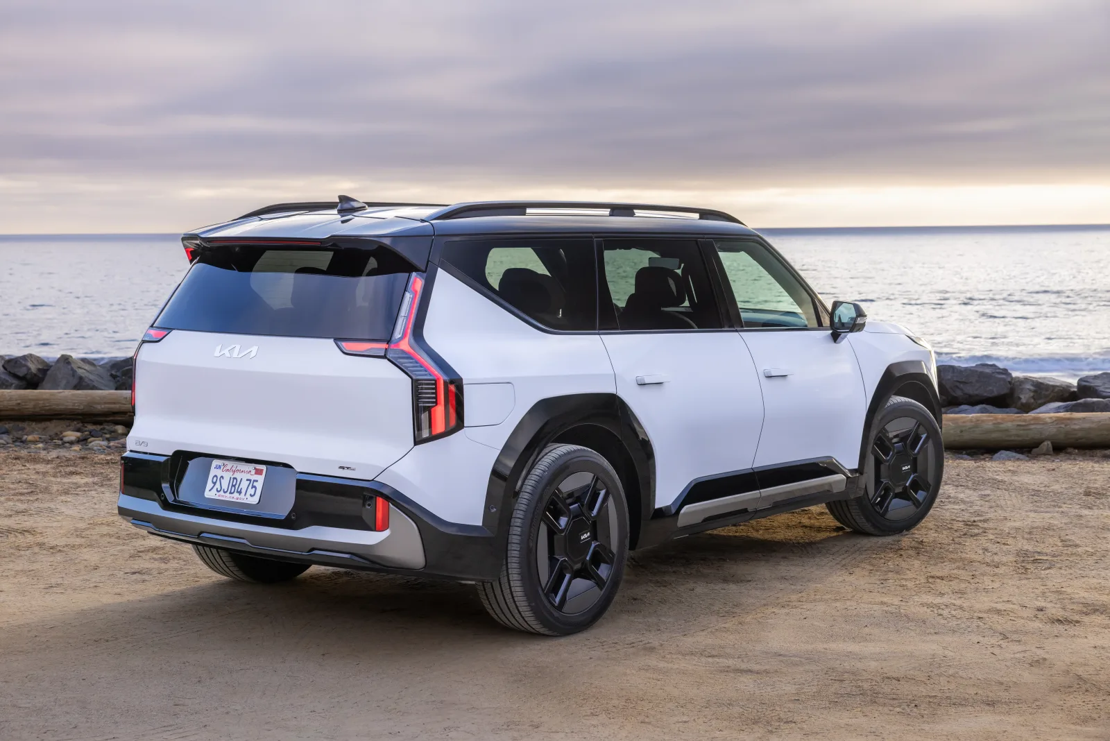 White 2026 Kia EV9, rear three-quarter on a coastal lot with star-map tail lamps