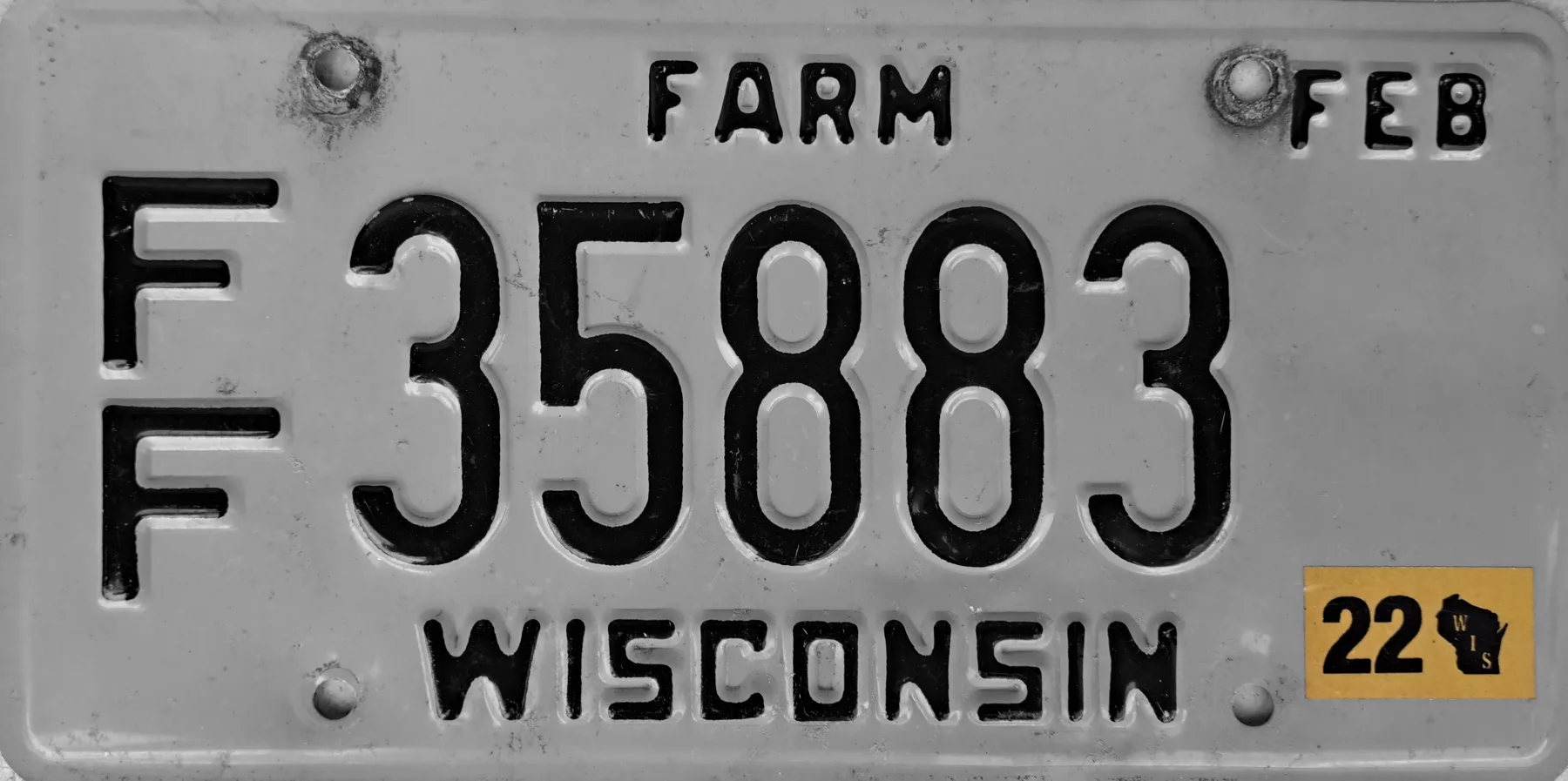 Wisconsin farm license plate reading FARM, with FEB at the upper right and a 22 year sticker at the lower right