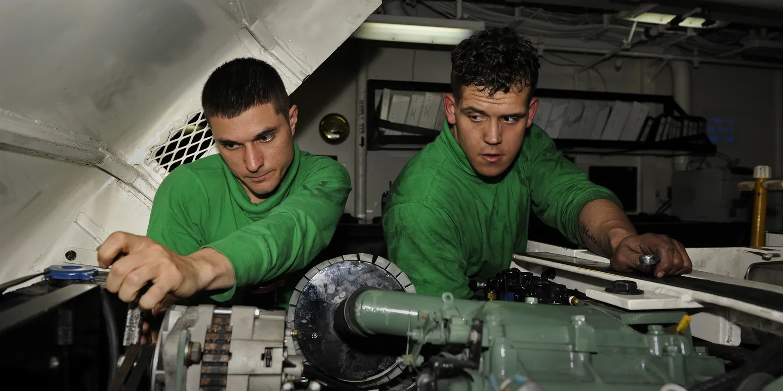 Technicians working at an engine and transmission connection