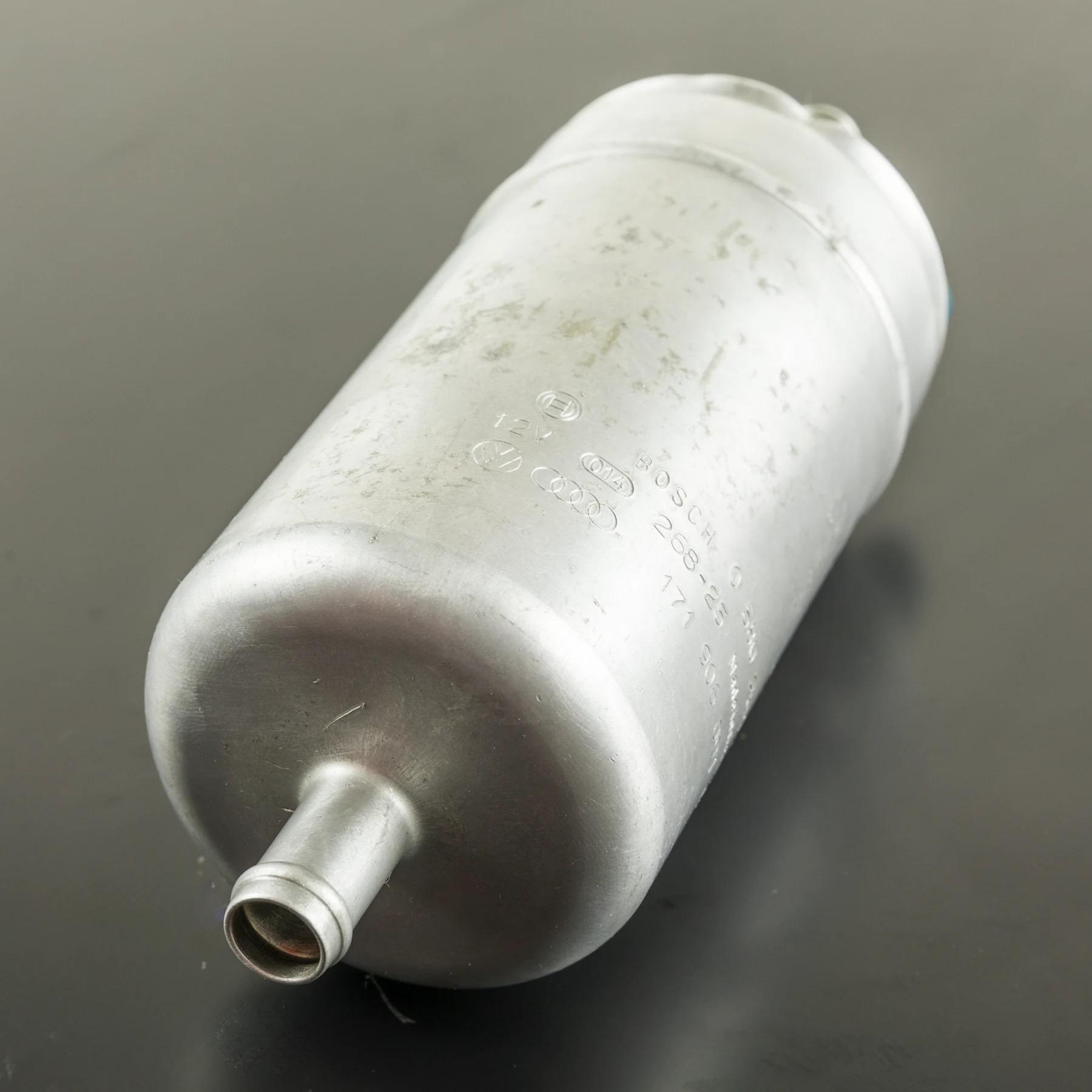 Cylindrical inline electric fuel pump with a fuel connection visible