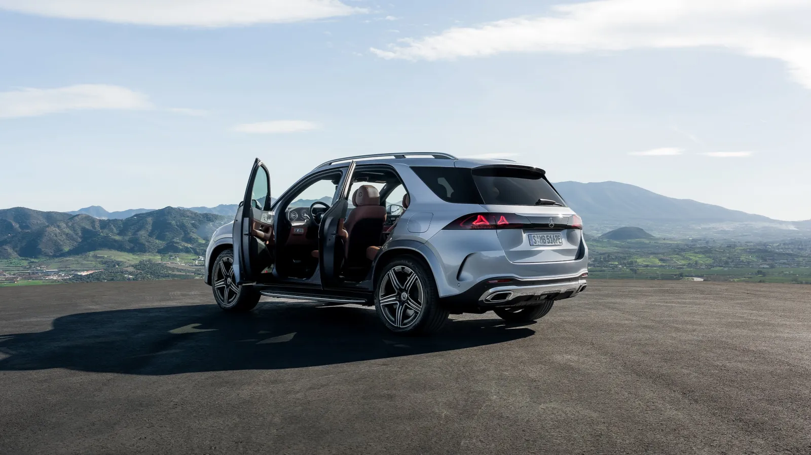 Silver 2027 Mercedes-Benz GLE, rear three-quarter with a pair of three-dimensional stars in each tail lamp
