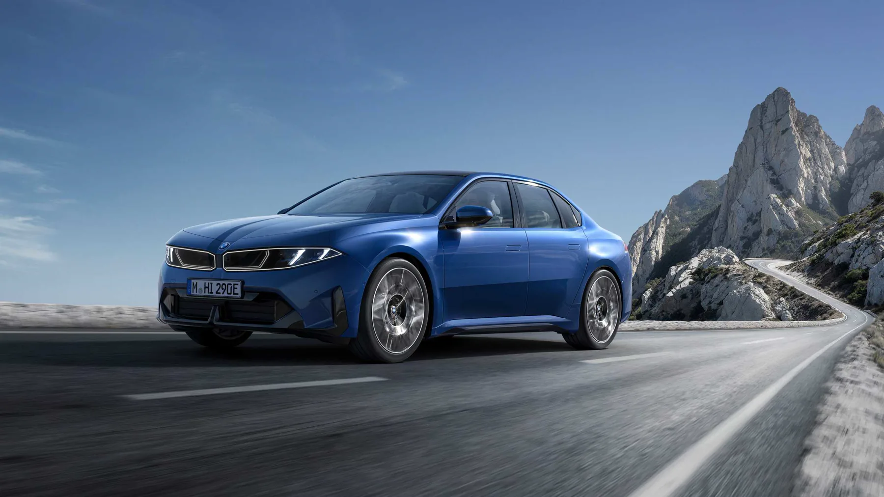 Blue 2026 BMW i3 50 xDrive, front three-quarter on a mountain road