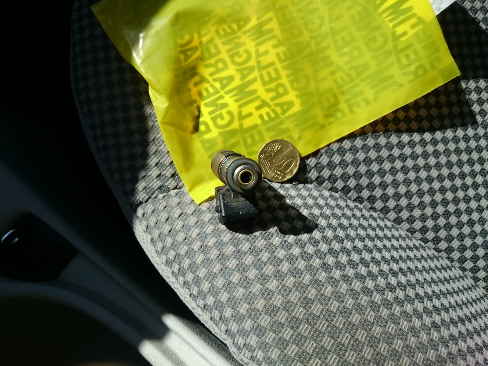 Fiat Stilo injector fuel-inlet end with a green O-ring, beside a 20-cent coin on a Magneti Marelli bag