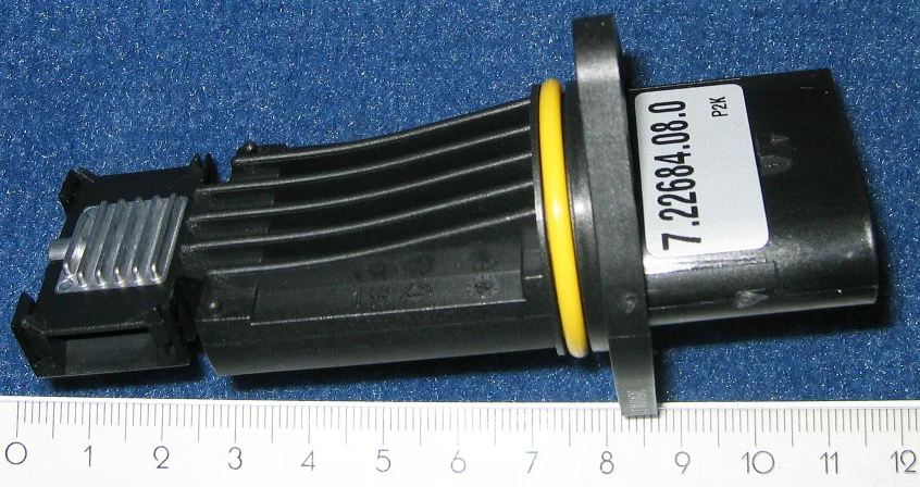 VAG-Pierburg mass airflow probe with a yellow O-ring, cooling fins, and a part-number label
