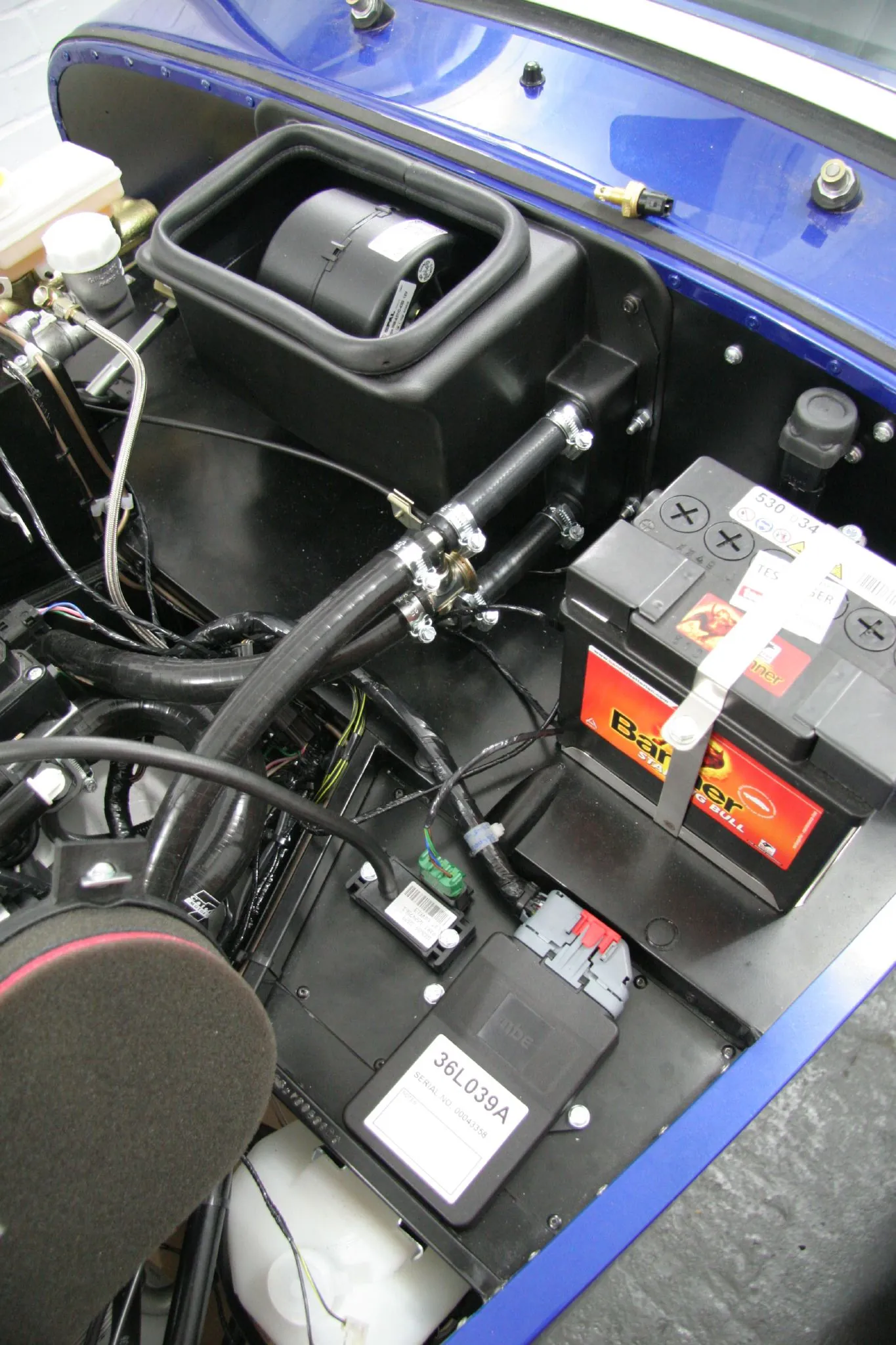 Engine bay with electronic-control hardware and hoses mounted at the bulkhead