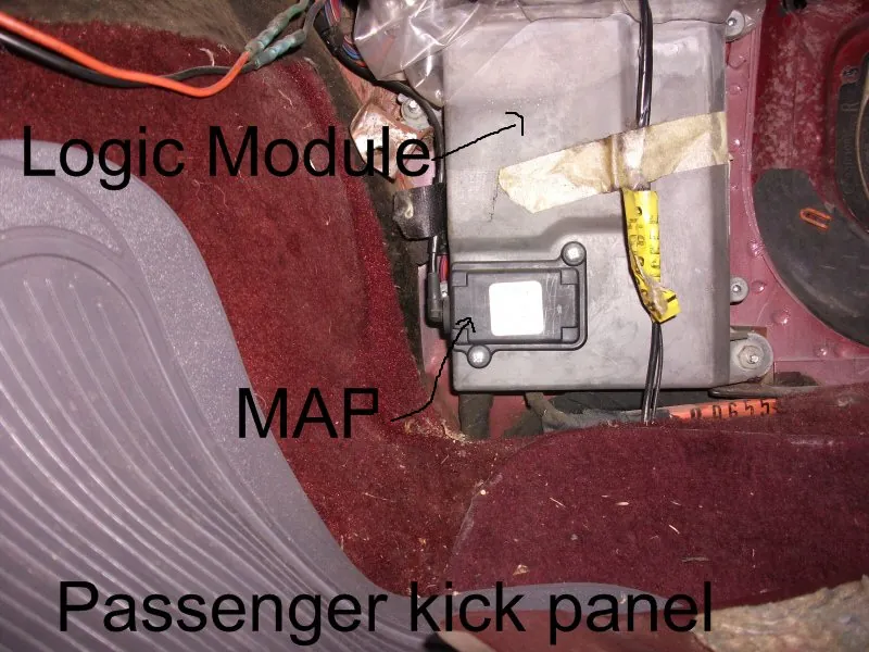 MAP sensor and vacuum hose behind the passenger kick panel of a 1986 Chrysler LeBaron, next to the logic module