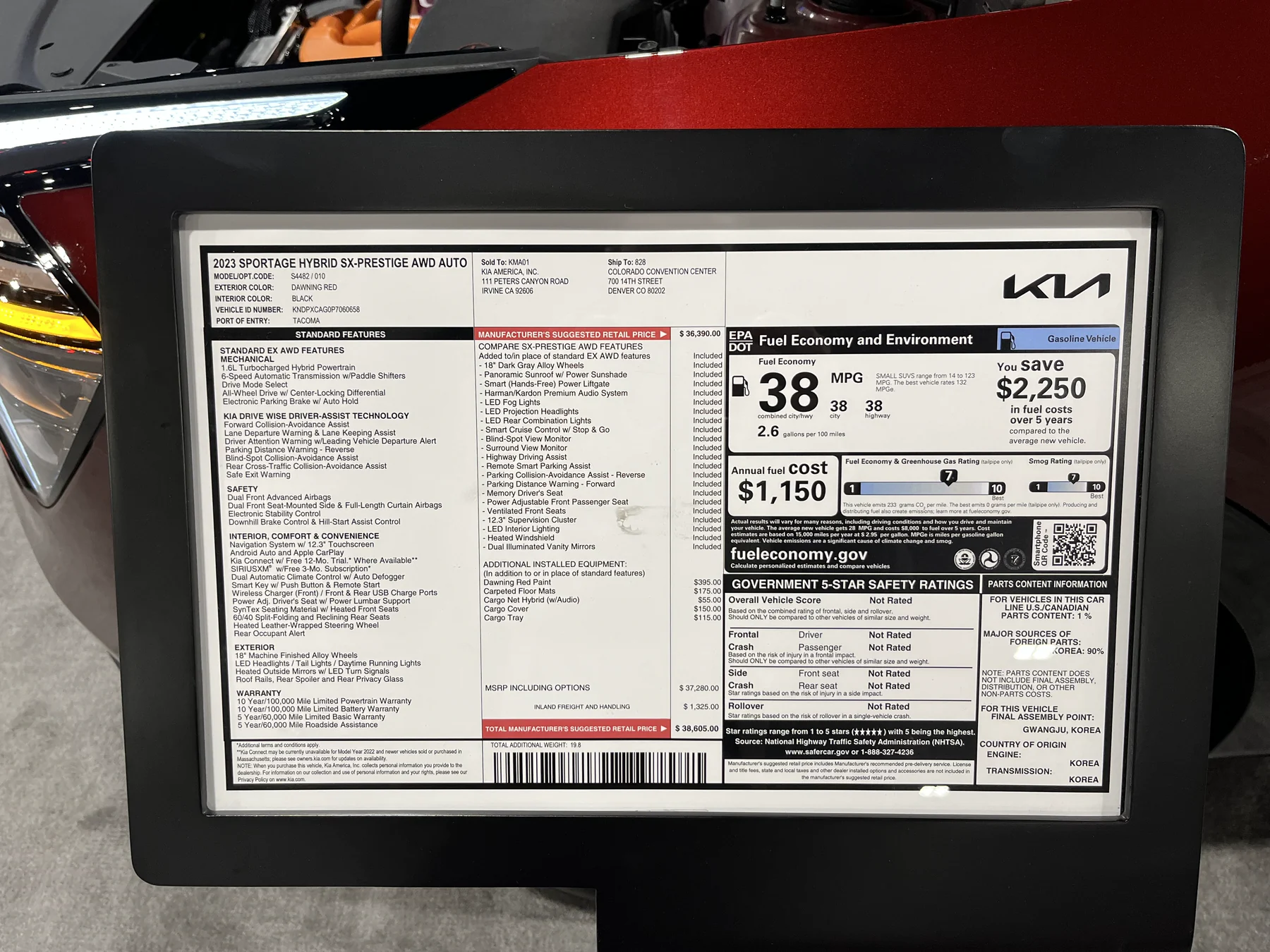 Kia Sportage Hybrid window-label display mounted on a board at an auto show
