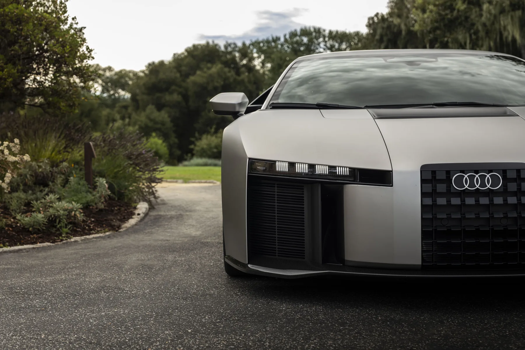 Close front three-quarter view of the gray Audi Nuvolari near-production prototype, showing its upright nose panel and rectangular lamp elements