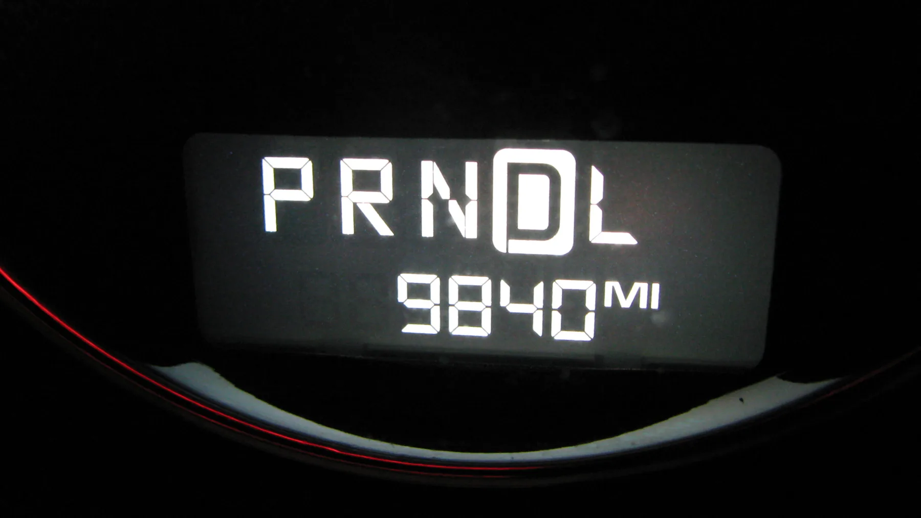 Digital instrument cluster showing 9840 miles next to the gear letters