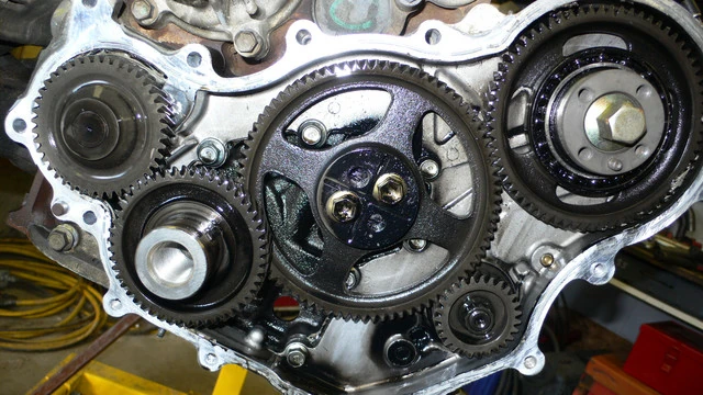 Toyota 1HZ timing gears with the engine on its side, the oil pump in the train with the crankshaft, an idler, the injection pump, and the power steering pump