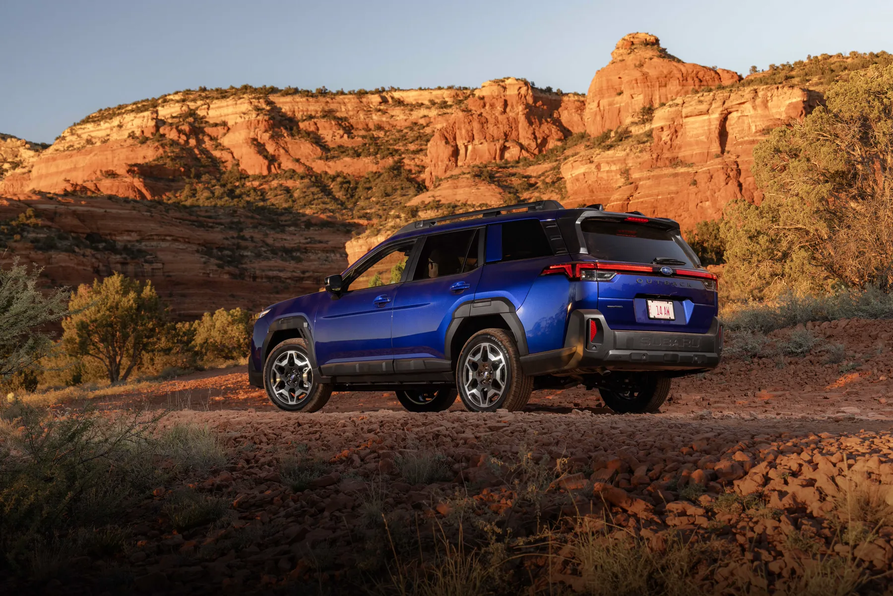 Blue 2026 Subaru Outback, rear three-quarter with a full-width light bar and OUTBACK lettering