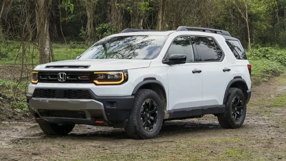 White 2026 Honda Passport TrailSport, front three-quarter on dirt with amber DRL bars and a two-bar grille