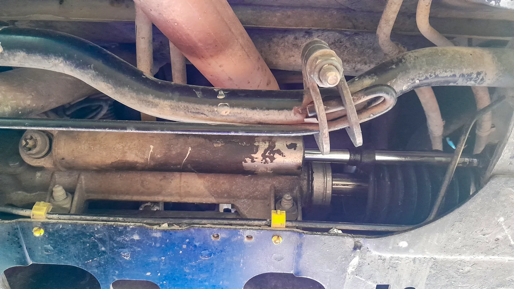 Underside steering mechanism with an external hydraulic assist cylinder beside the rack