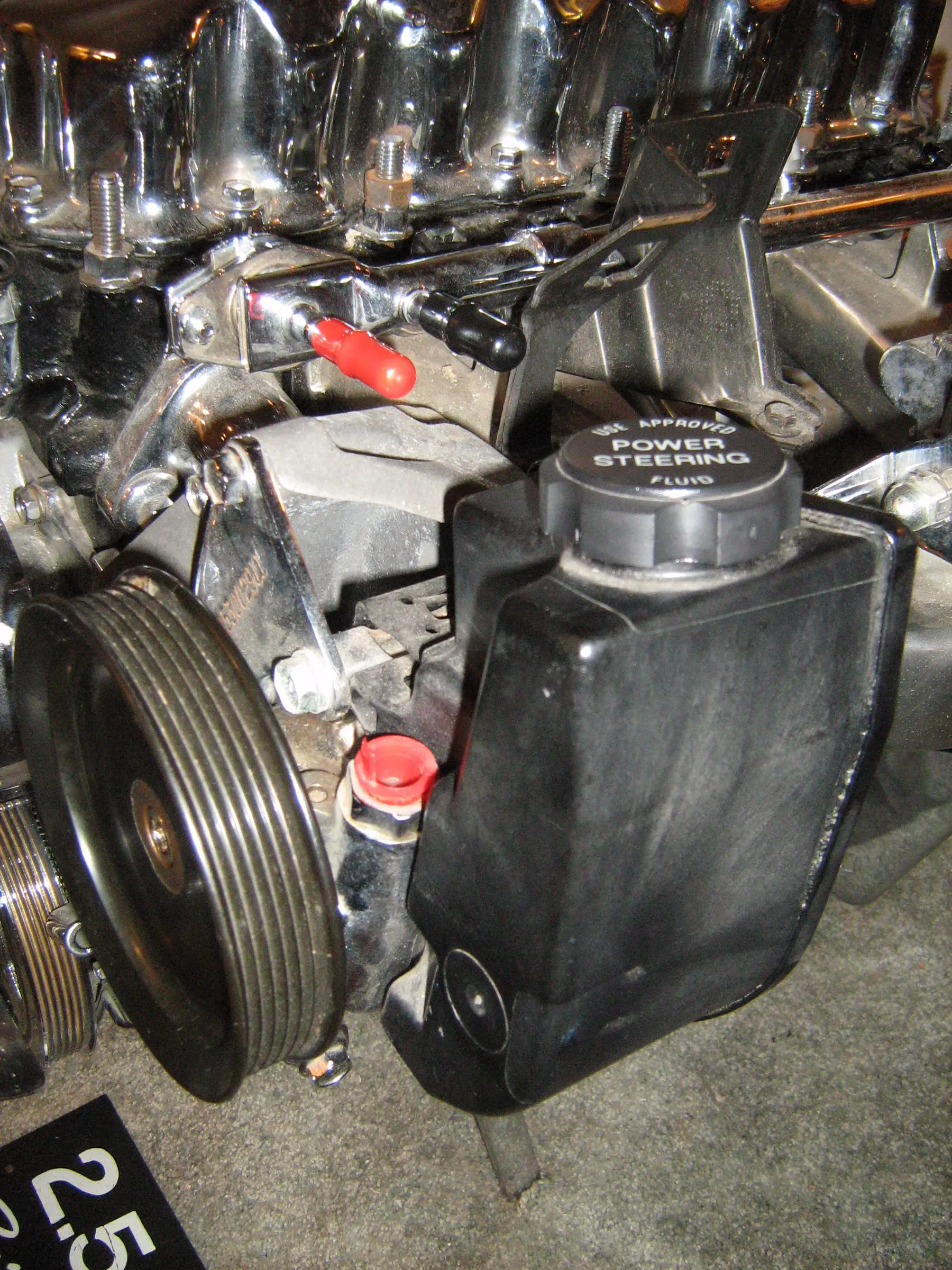 Chromed Jeep 2.5 display engine with a belt-driven power steering pump, grooved pulley, and reservoir on the front of the block