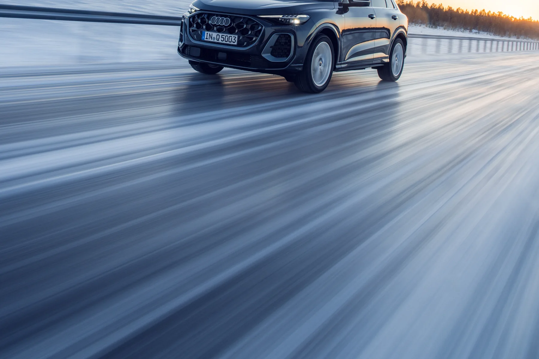Tambora-grey 2026 Audi Q5, front three-quarter on a snowy road with a high Singleframe and slim digital daytime lamps