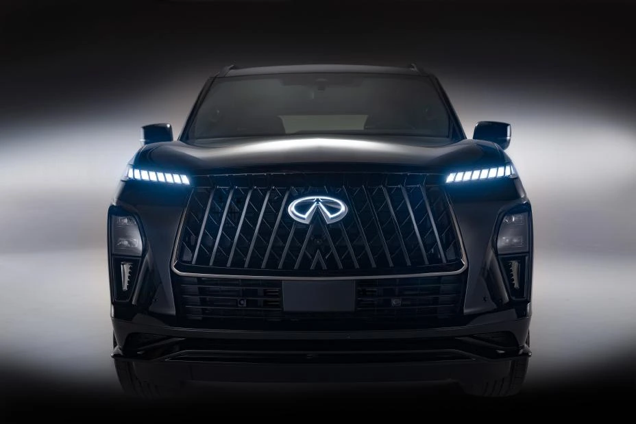 Black 2026 Infiniti QX80 SPORT, dead-front in studio with a double-arch grille, piano-key DRLs, and an illuminated Infiniti emblem