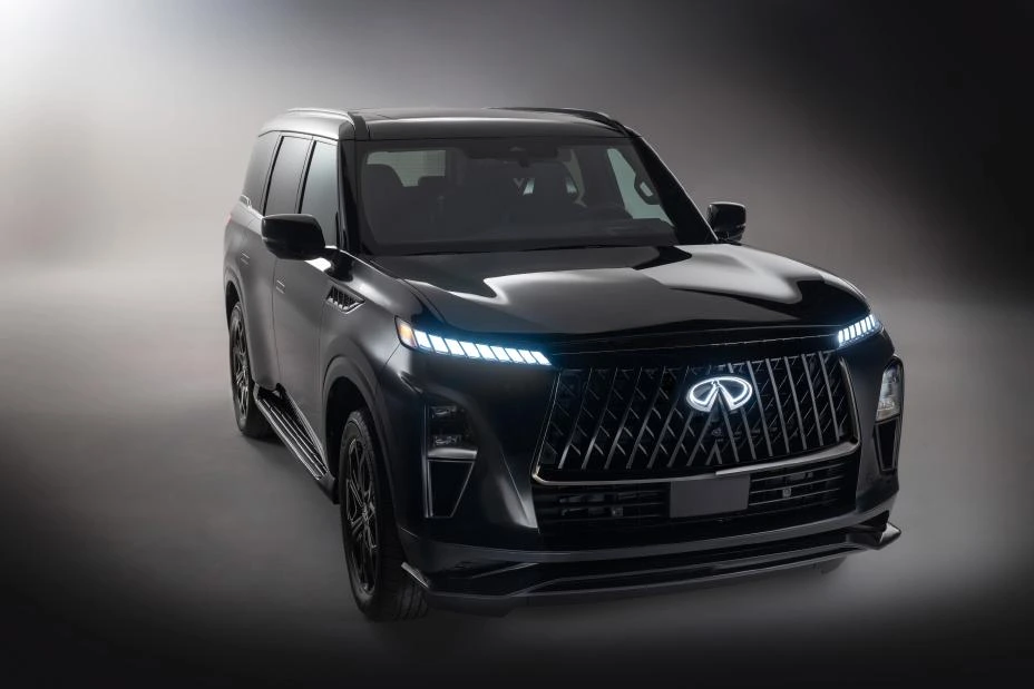 Black 2026 Infiniti QX80 SPORT, front three-quarter in studio with piano-key DRLs lit on a double-arch grille