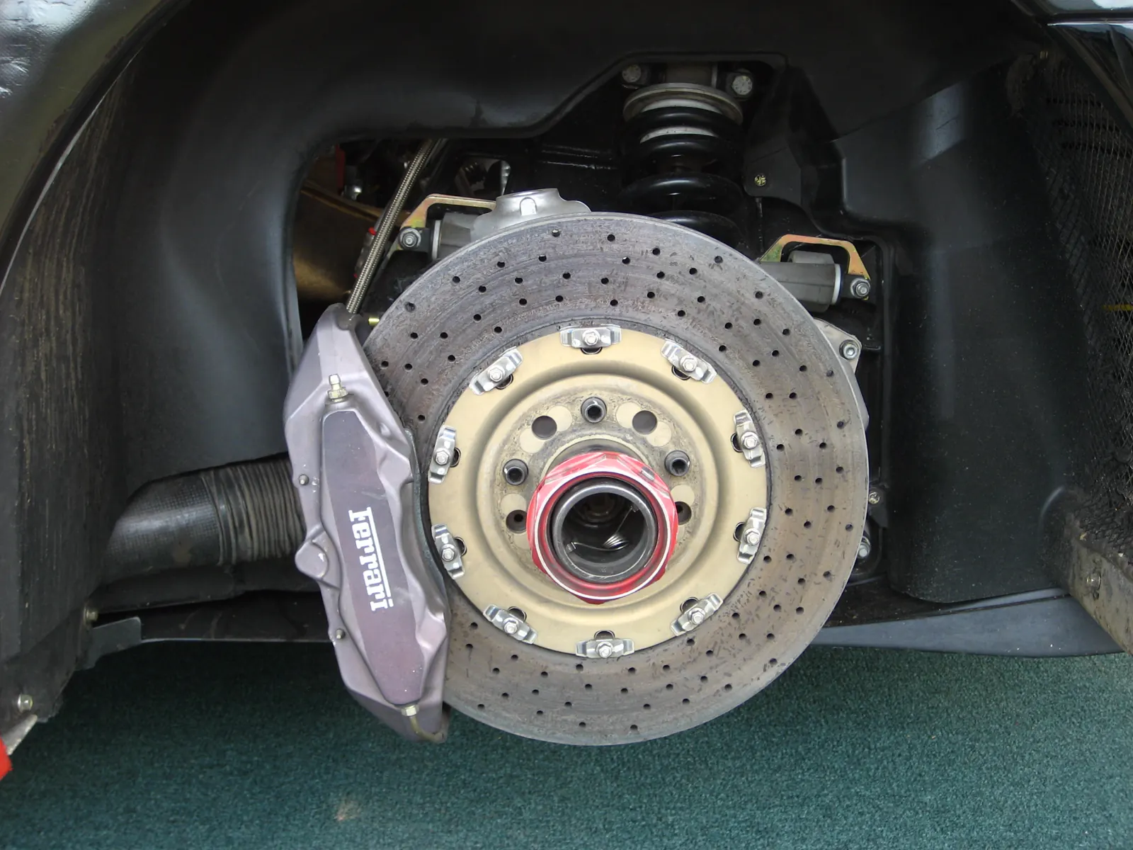 Ferrari F430 Challenge drilled brake disc and grey caliper, wheel off, hat bolted to the hub
