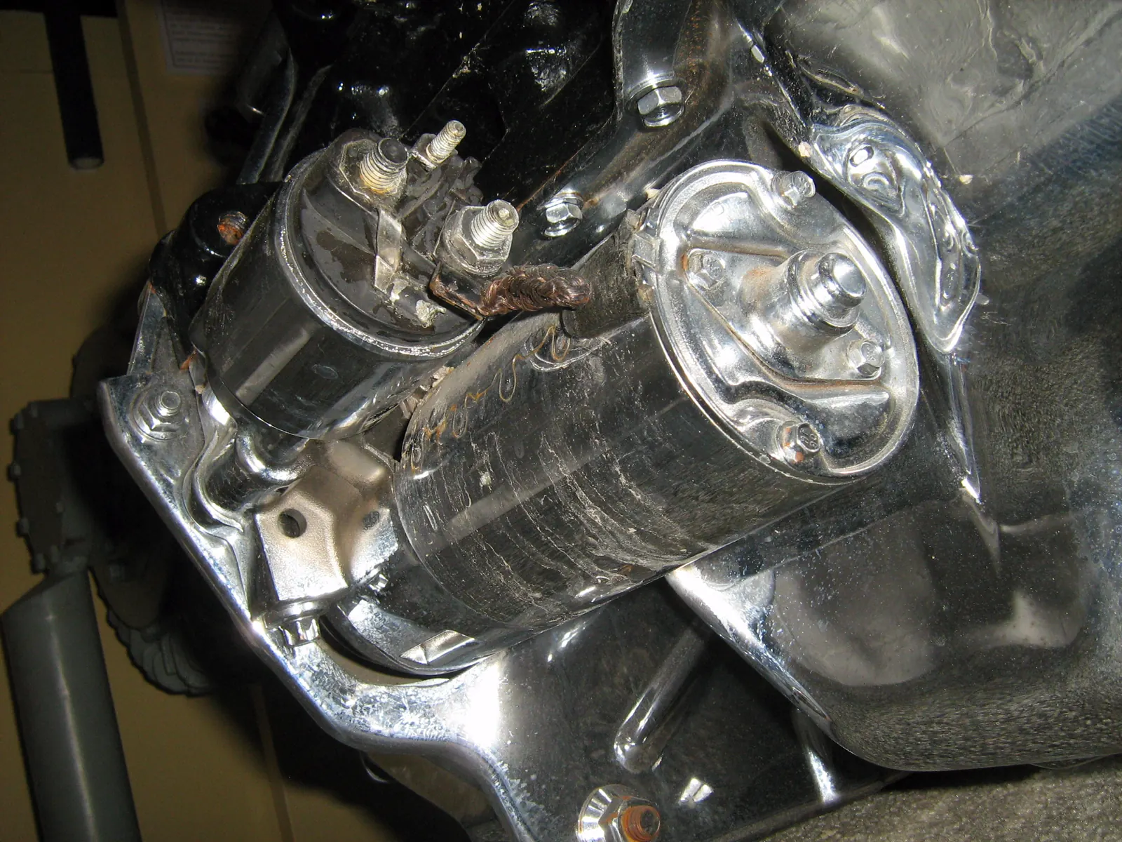 Chrome Jeep 2.5 starter bolted under the engine, solenoid on top of the motor case