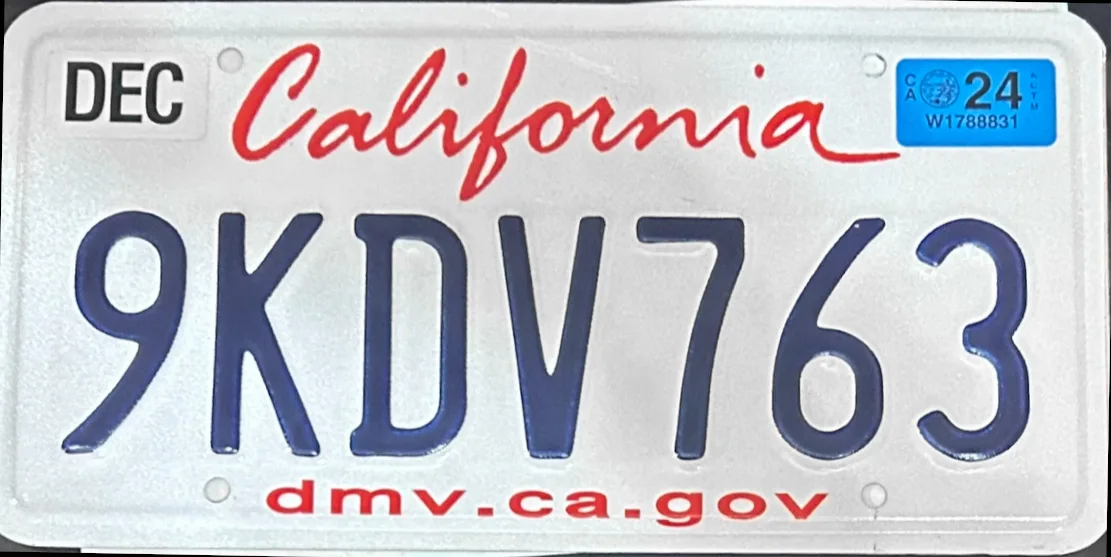 California rear plate with a December month tab and a blue 24 year tab