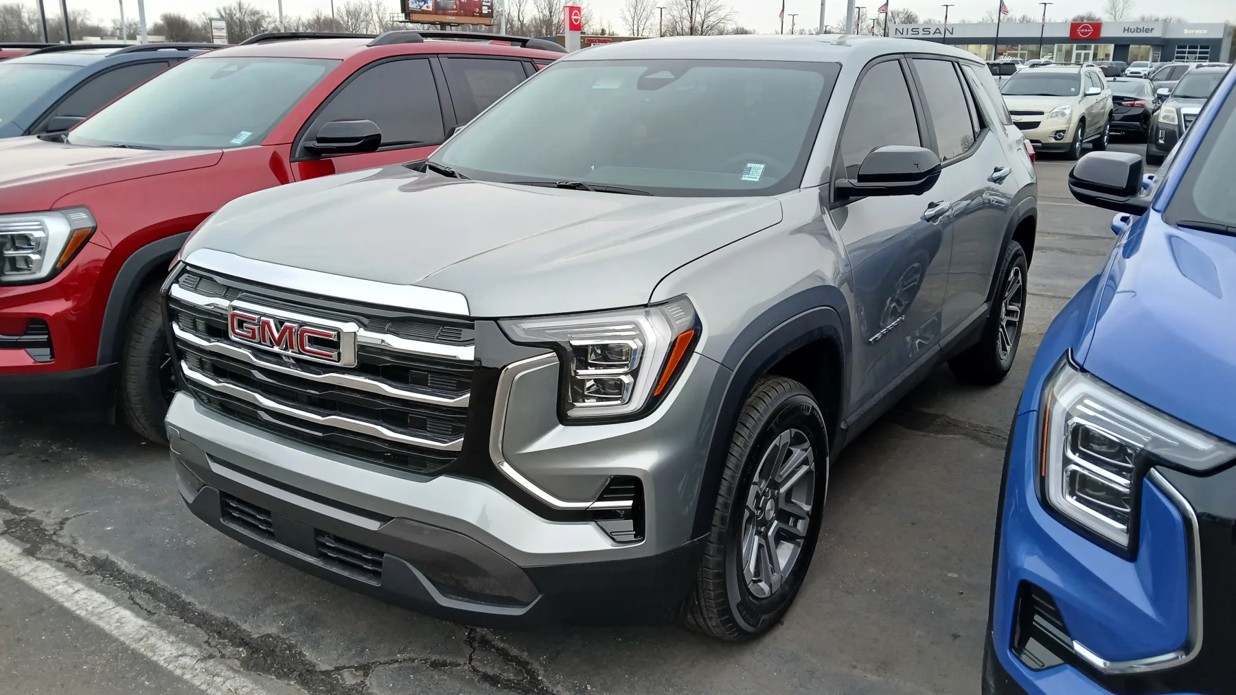 Front view of a 2025 GMC Terrain Elevation with a bright surround from the headlamps down around the fog lamps and an upright grille