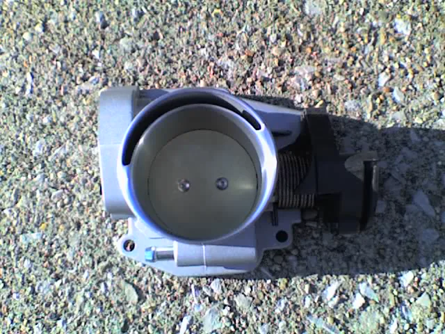 Chrysler PowerTech V6 throttle body on pavement, closed butterfly plate and cable linkage on the housing