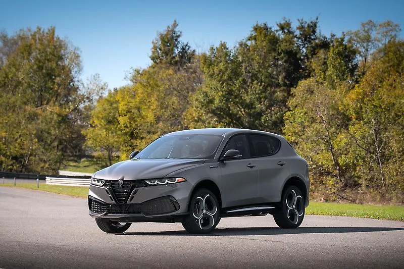 Gray 2026 Alfa Romeo Tonale Sport Speciale, front three-quarter on a tree-lined road with a concave scudetto and trilobe intakes