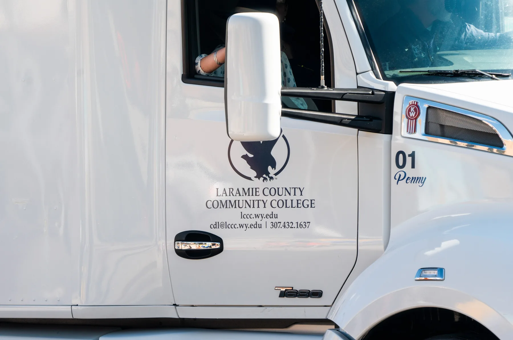White truck in a parade with Laramie County Community College lettered on the door