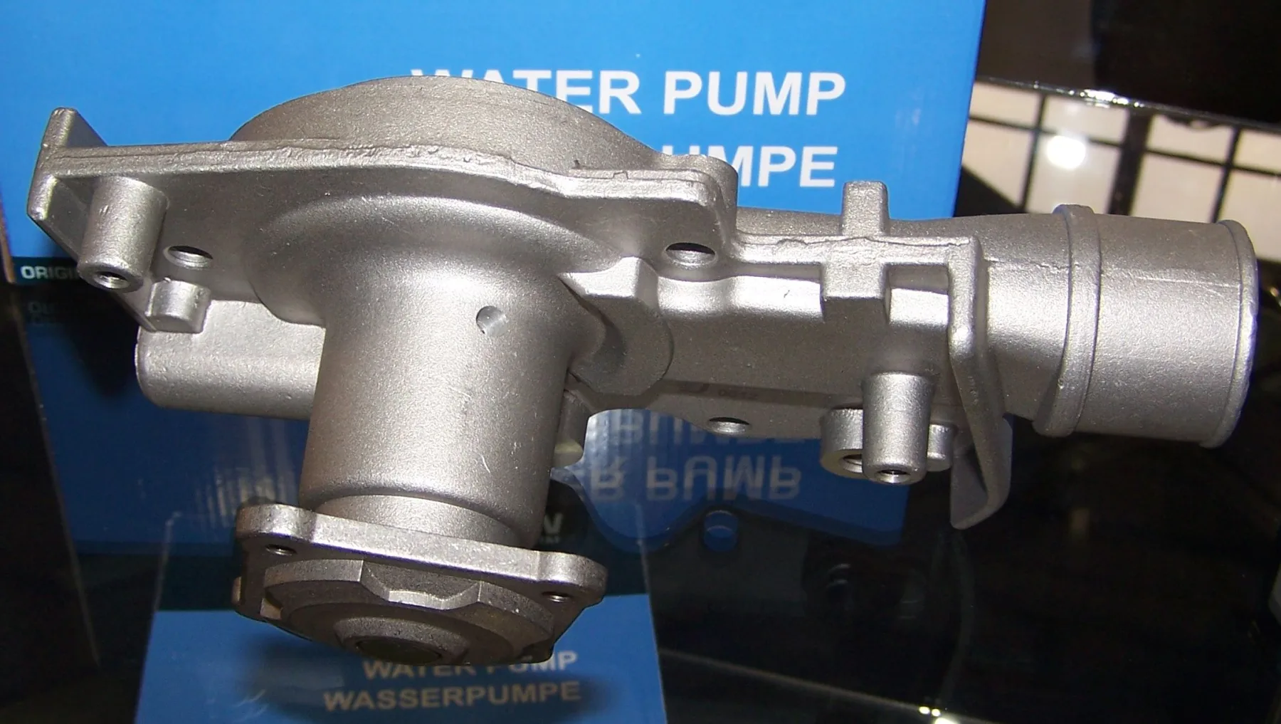 Cast automotive water pump with a pulley hub, coolant neck, and mounting ears