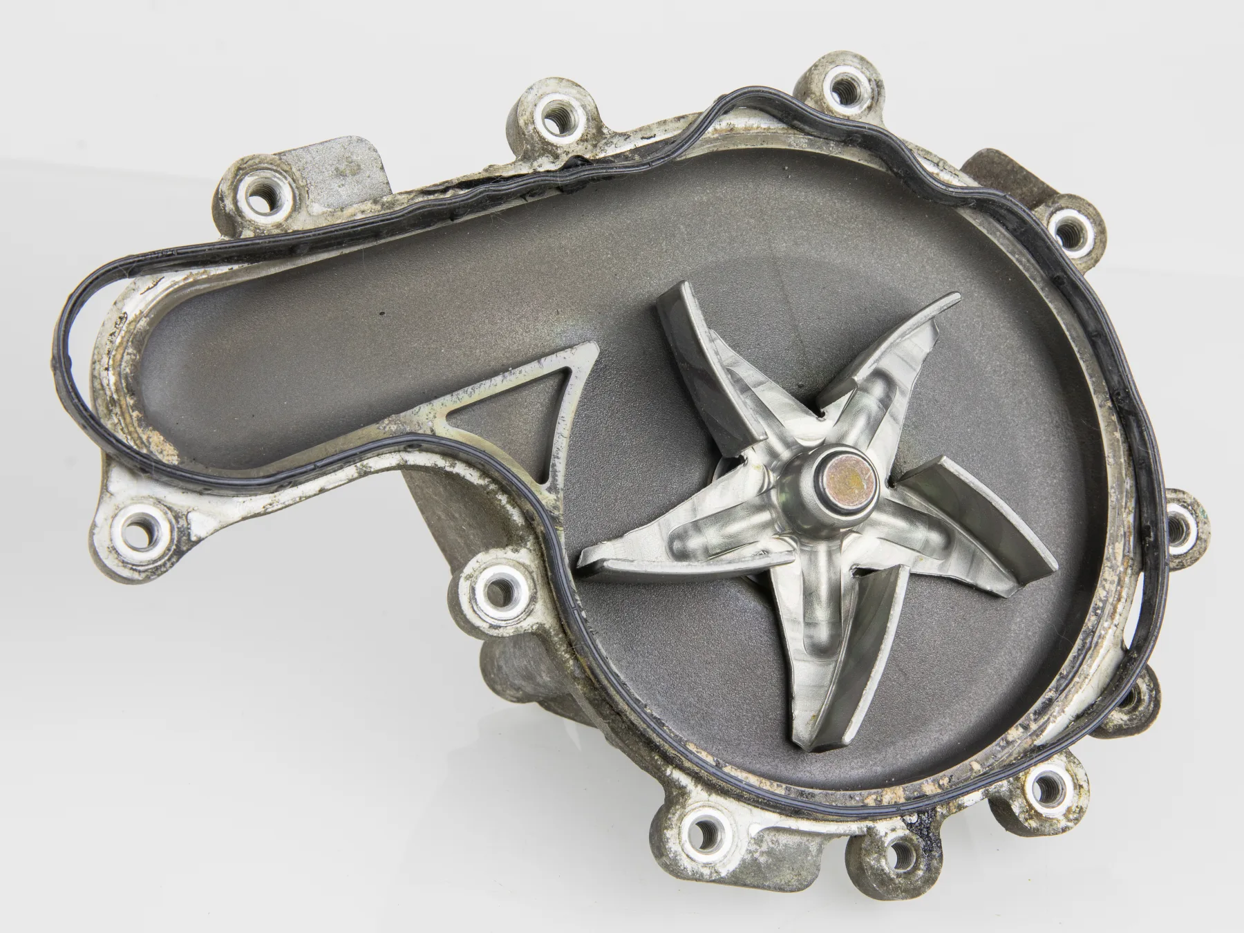 Opened automotive water pump showing a five-blade impeller in a cast housing