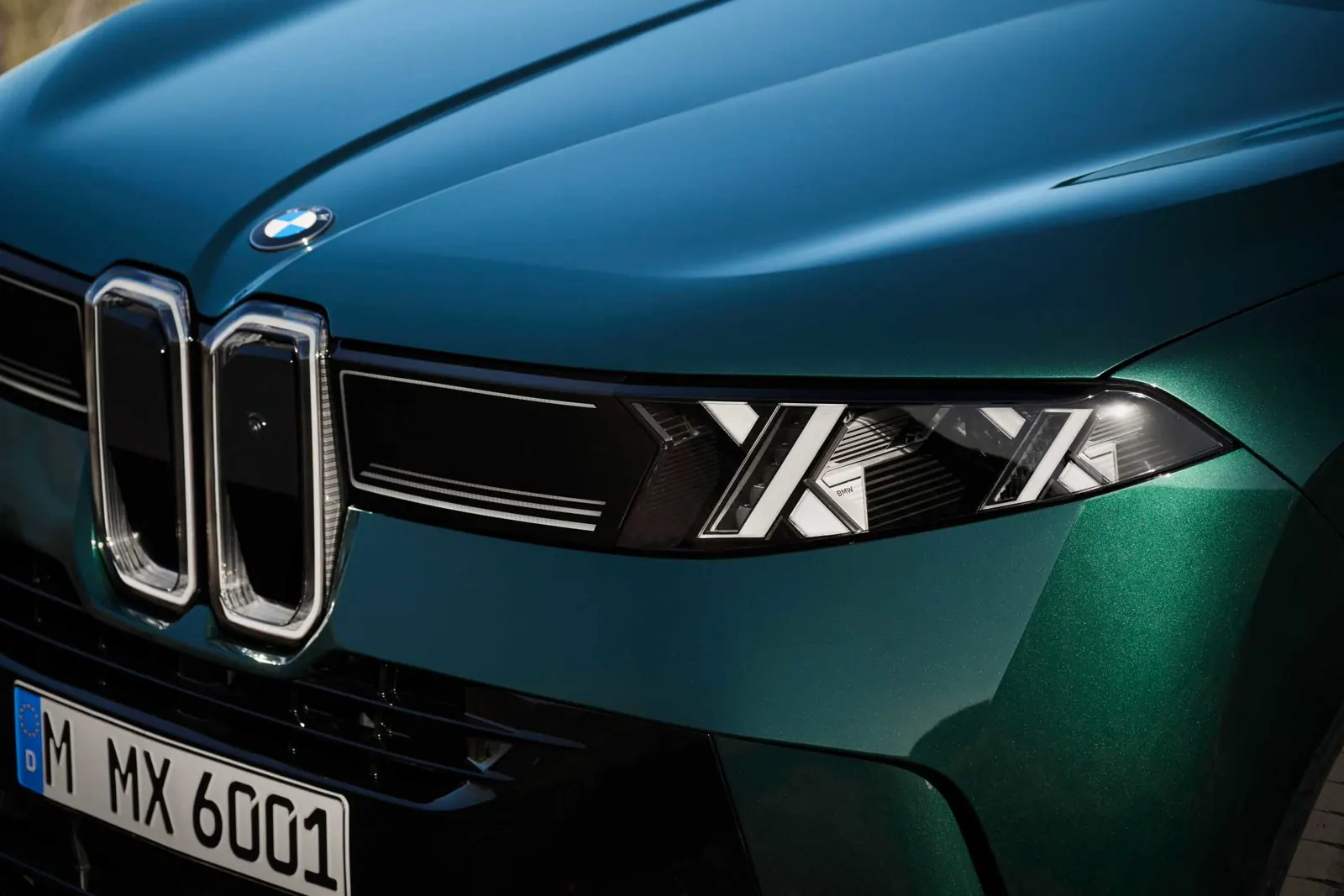 Close 2027 BMW X5 double-X lamp and vertical kidney Iconic Glow on a green fascia